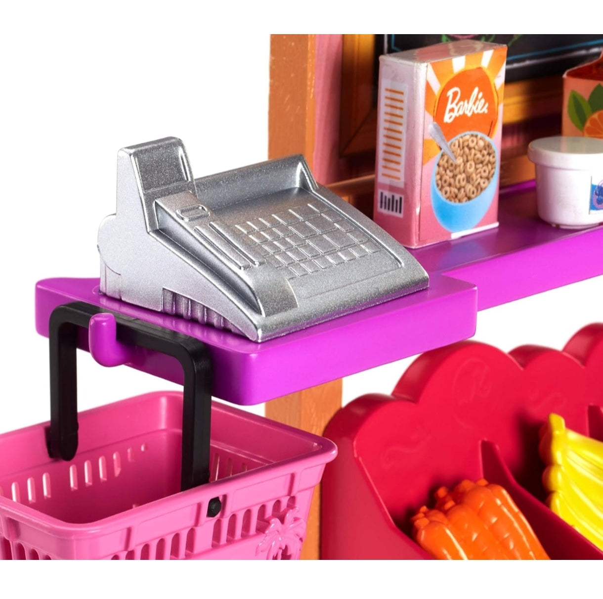 Toy cash register on a toy shelf with a pink basket and colorful items