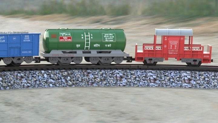 Centy cargo train battery operated toy with blue, green, and red cargo cars on a curved track outdoors