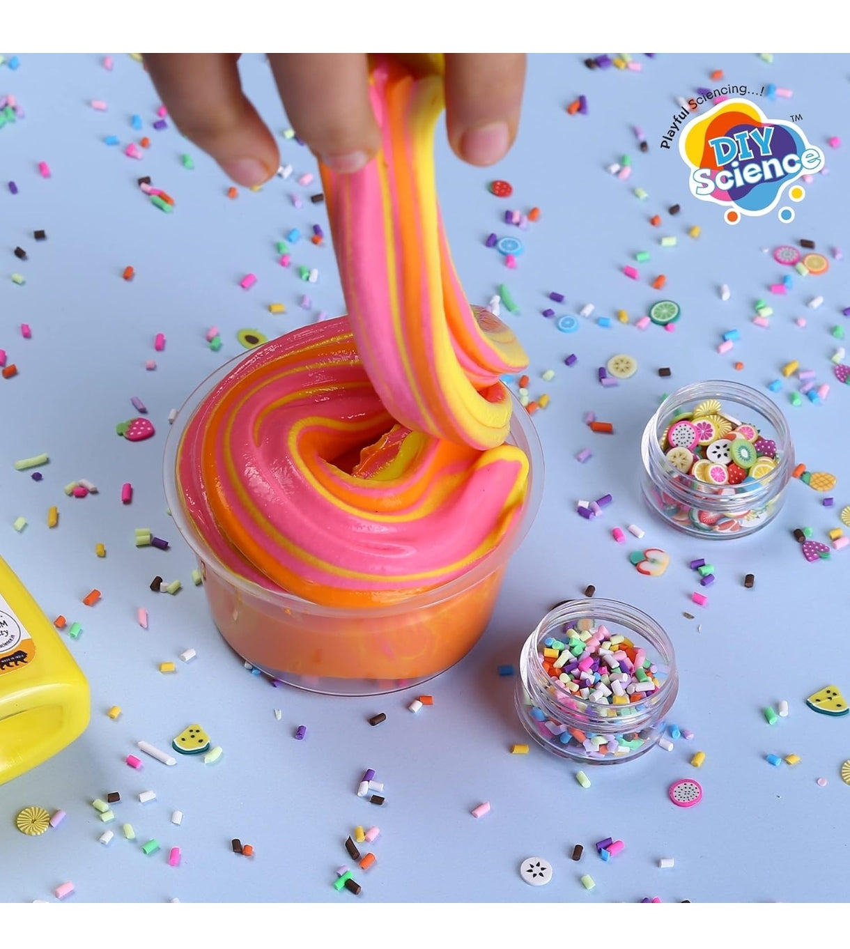 Colorful DIY kit for slime with pink and orange slime and various toppings for creative fun