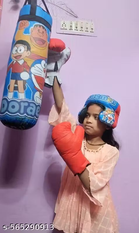 Child wearing boxing gloves and a helmet, standing next to a colorful punching bag against a light purple wall.