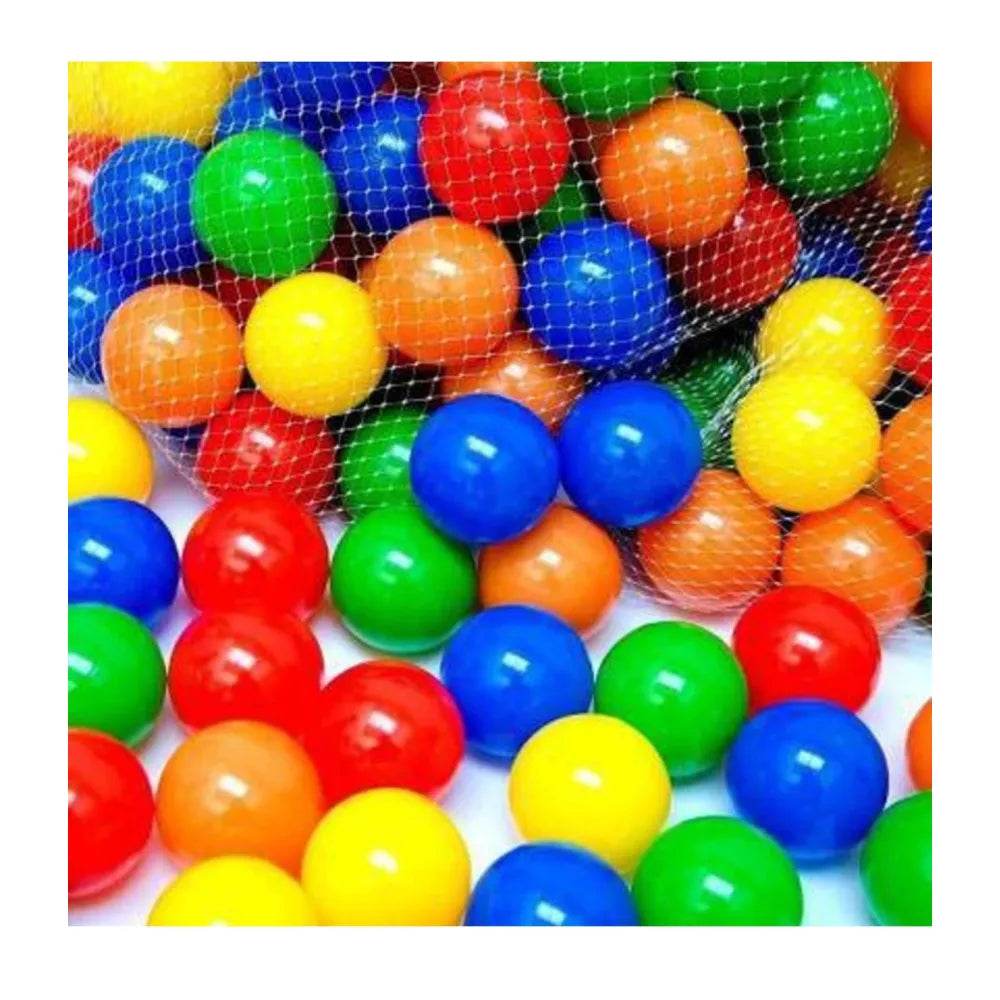 Colorful plastic balls for dinosaur ball pool for kids in a mesh bag and scattered on white surface