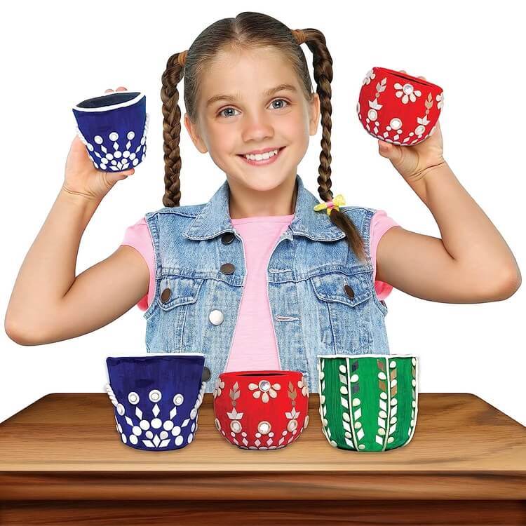 Happy girl holding colorful painted pots using Lippan art kit for kids by T-Rex the toyland Sitamarhi