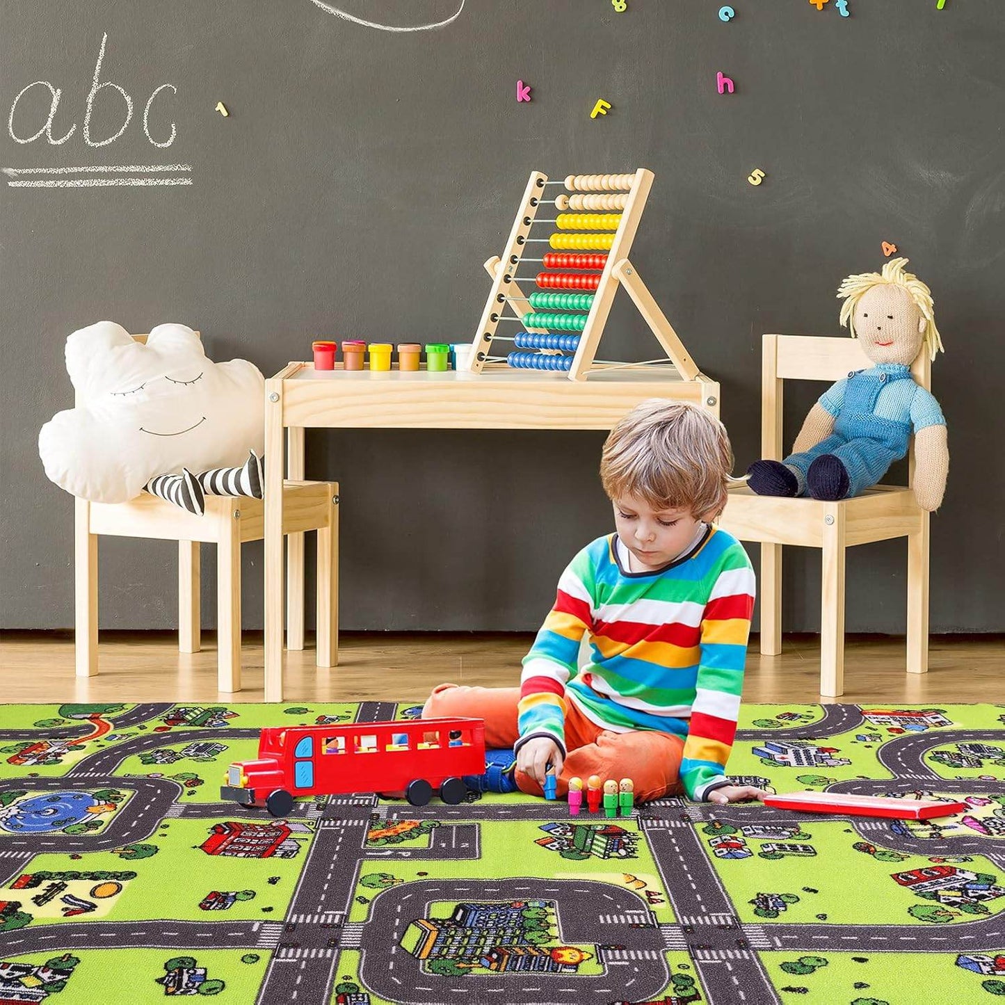Child playing with a city road play mat for kids, featuring roads and vehicles in a colorful playroom