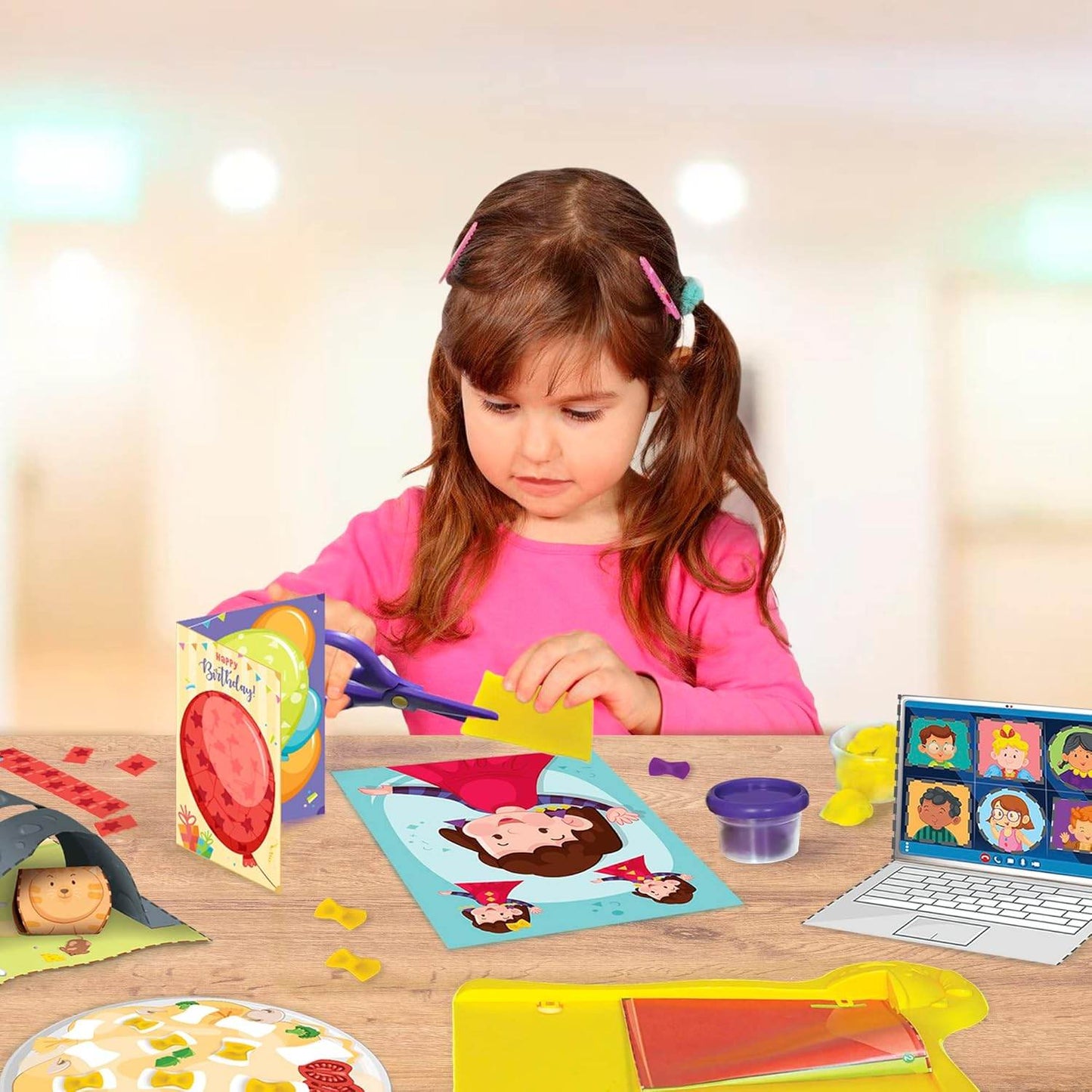 Young girl using scissors to work on a kids DIY craft kit with colorful paper and play clay on a table