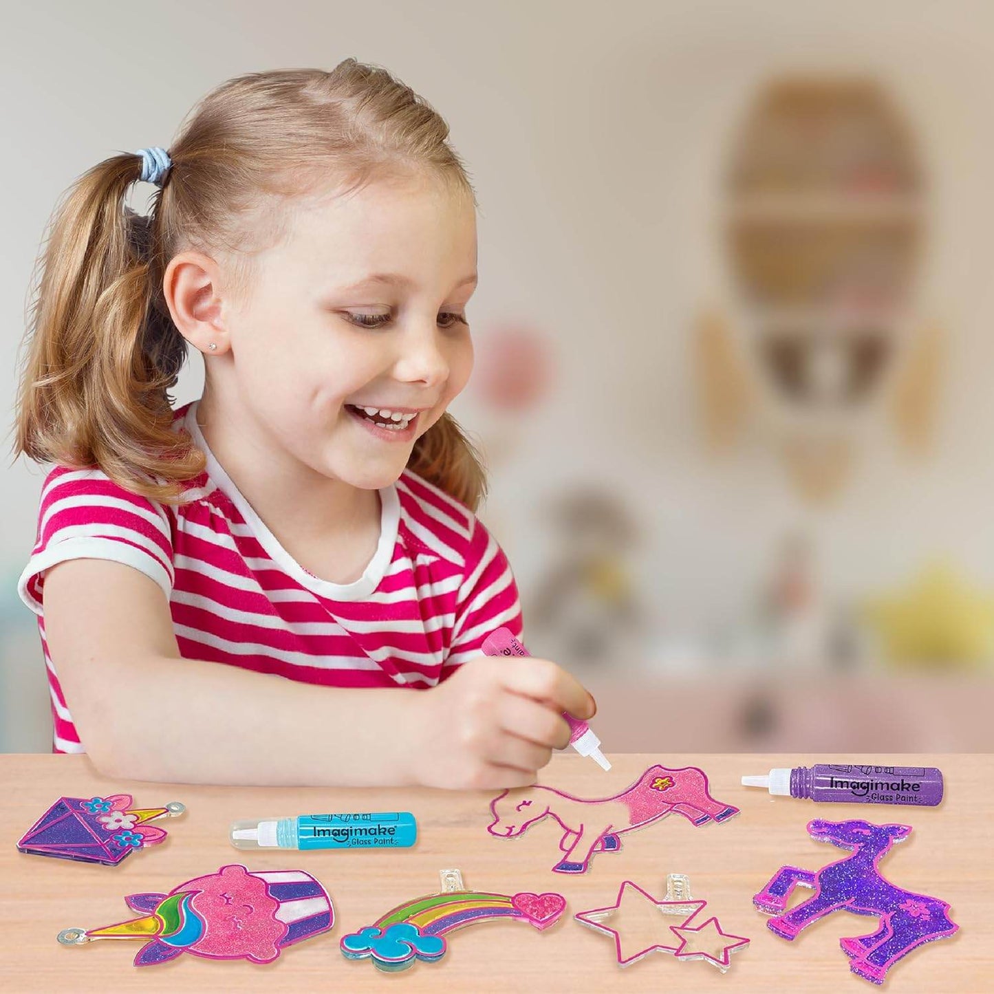 Young girl creating colorful unicorn window art kit decorations with markers at a table