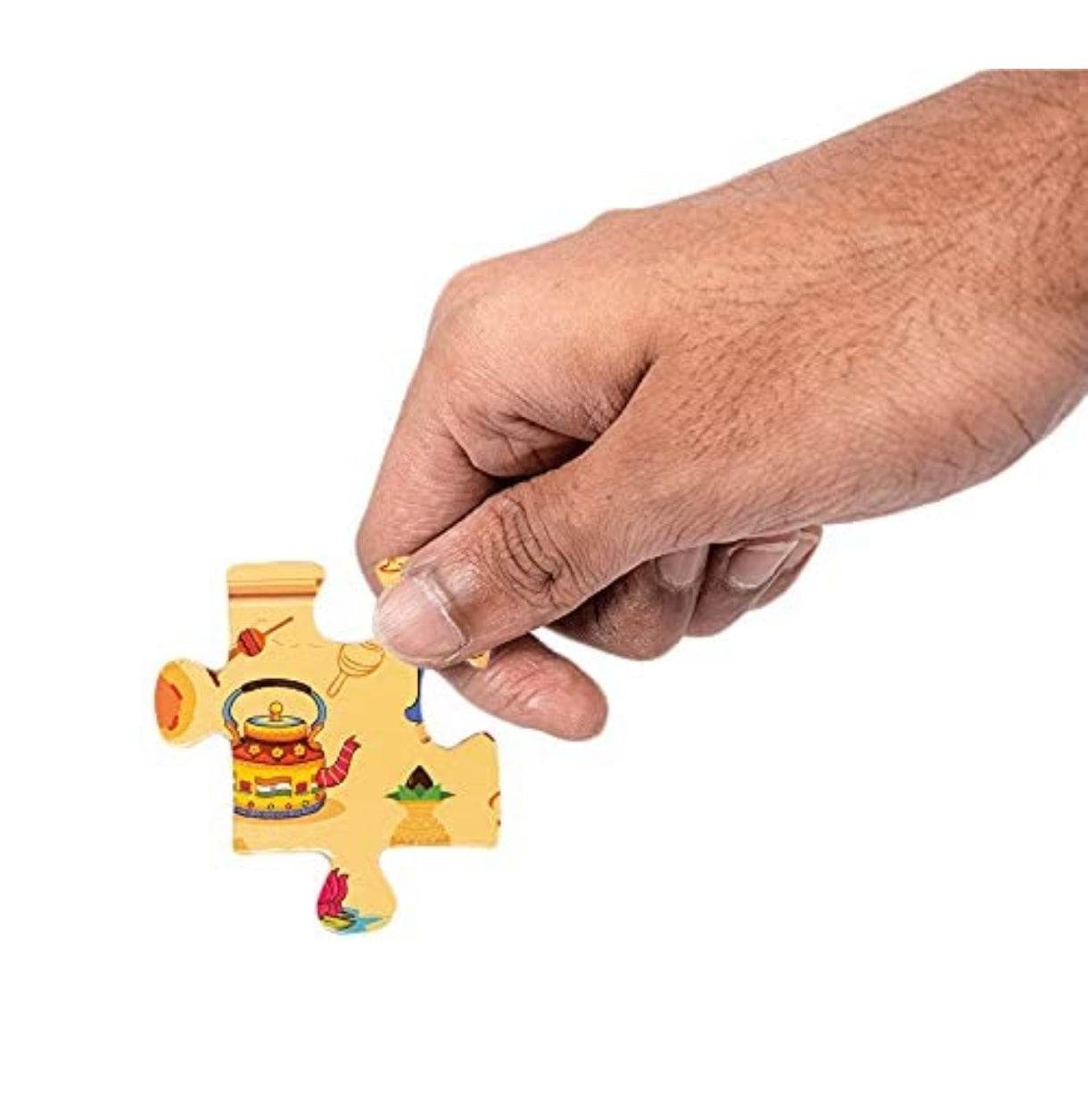 Hand holding a puzzle piece from an India map jigsaw puzzle for kids with colorful illustrations