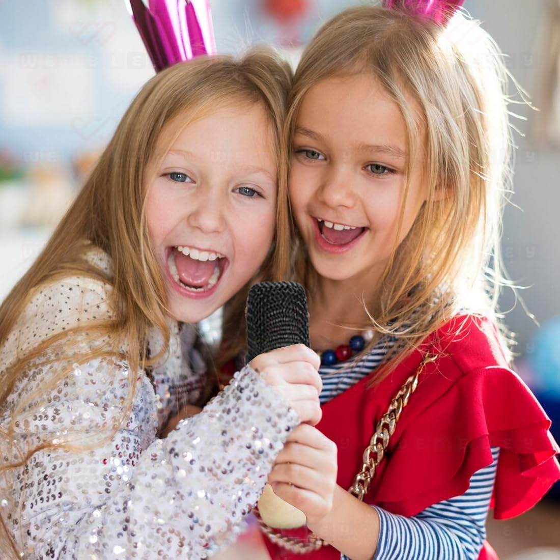 Two girls singing together with a microphone machine karaoke for children's parties