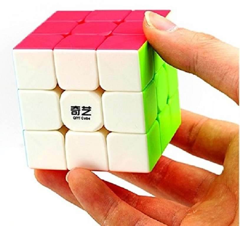 Hand holding a colorful 3x3 cube for kids puzzle toy with white, red, and green faces