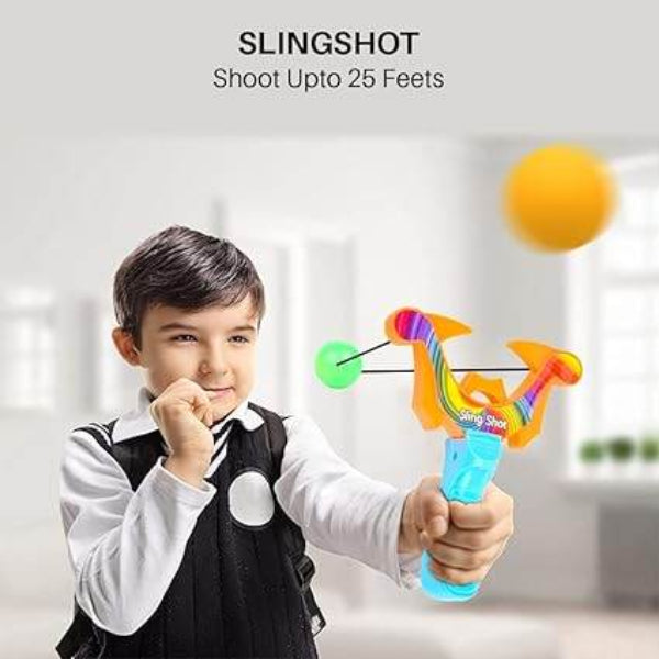 Young boy aiming colorful plastic ball slingshot game indoors launching a green ball in living room