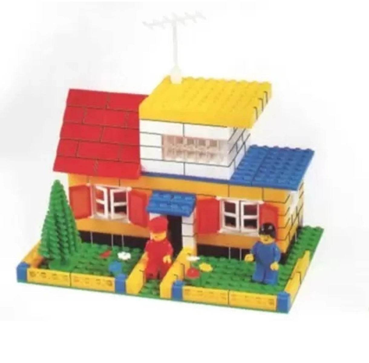 Educational construction toy set featuring a colorful block house with red roof and two mini figures playing in the garden