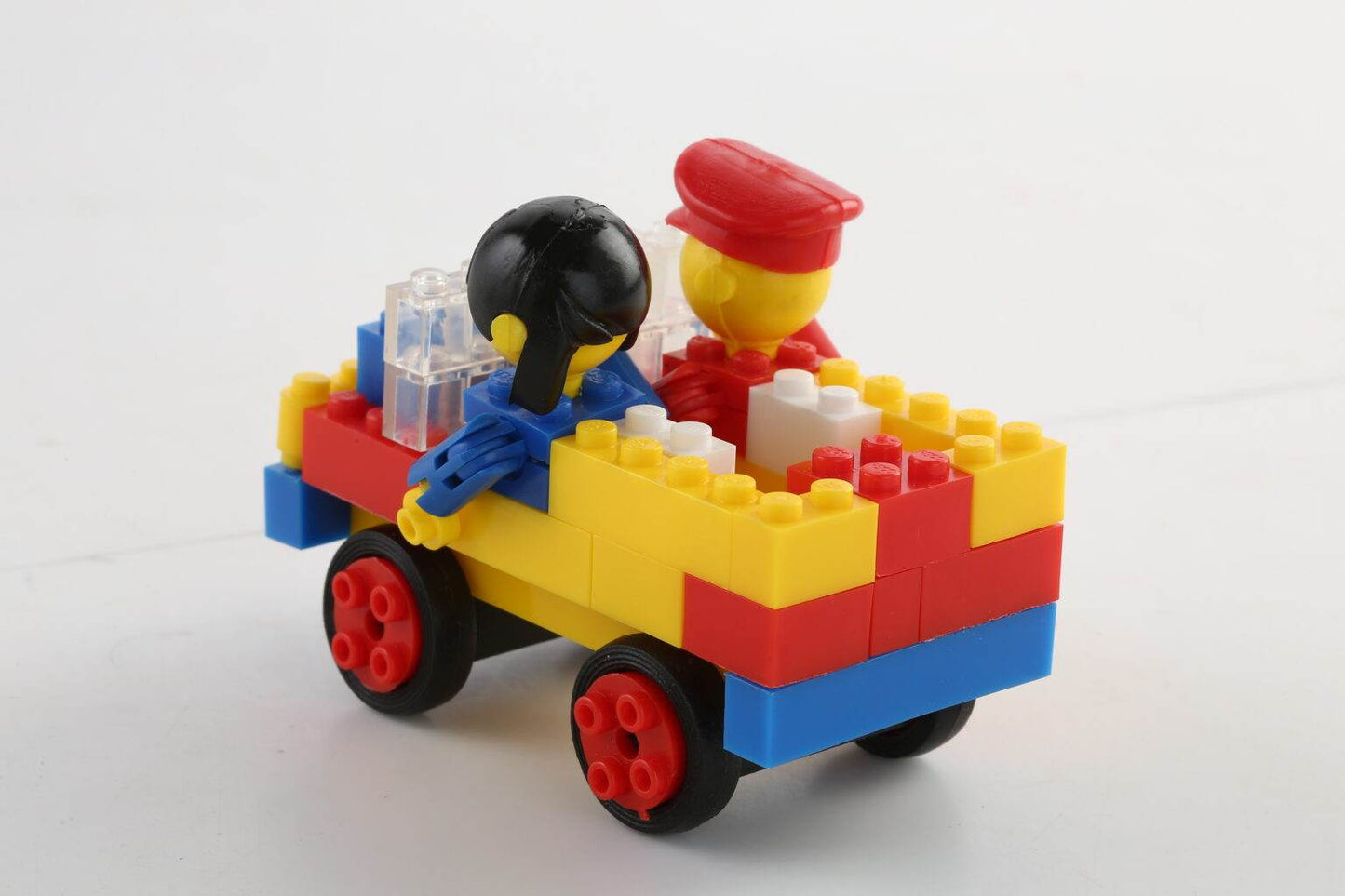 Colorful interlocking building toys for kids assembled as a small toy vehicle with two mini figures