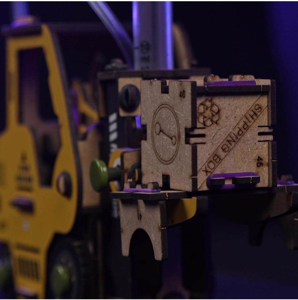 Hydraulic forklift toy for kids lifting a small wooden shipping box with detailed features