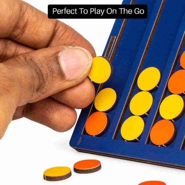 Hand placing a yellow chip on a blue board game set featuring orange and yellow chips Pocket Plot 4 game