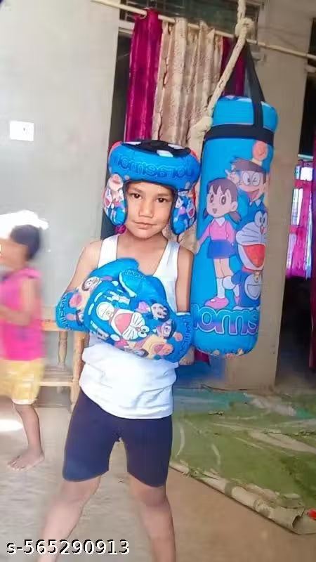 Child holding cartoon-themed boxing gloves and punching bag in an indoor setting