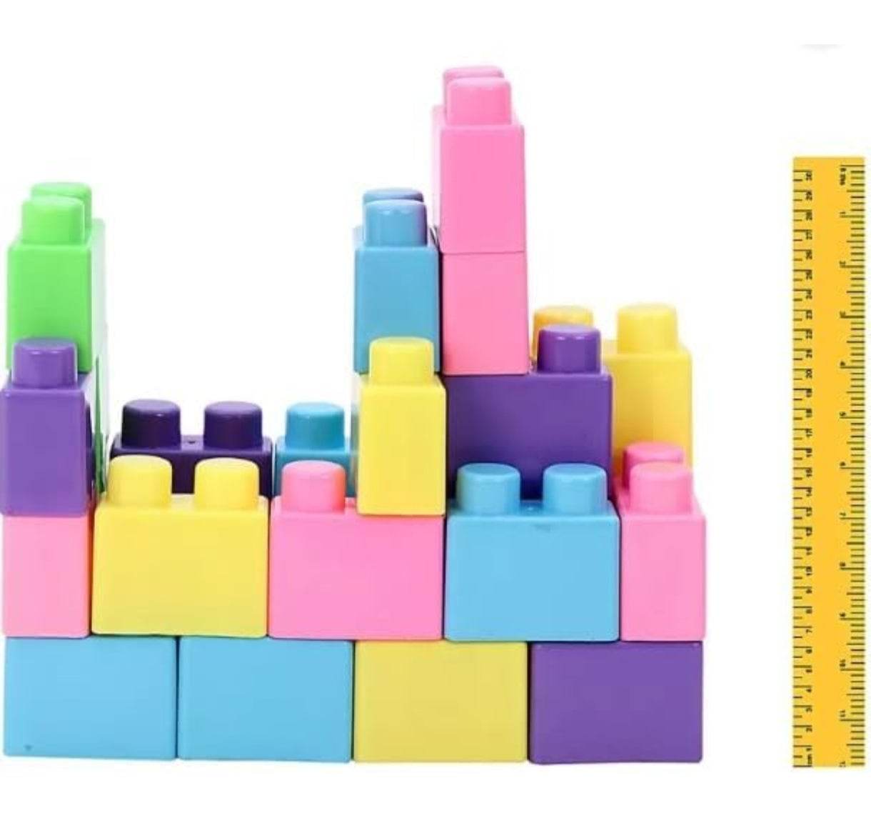 Colorful Unicorn building blocks set arranged in a castle shape next to a yellow ruler for size reference