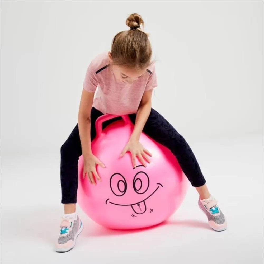Child playing with a bright pink unicorn hopper ball for kids featuring a smiling face and handle