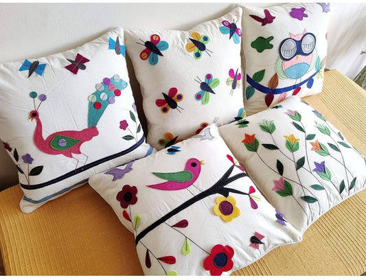 Set of decorative pillows with colorful patterns on a wooden surface