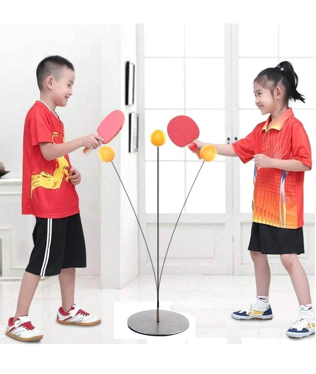Kids playing table tennis ping with red paddles and orange balls in a bright indoor setting