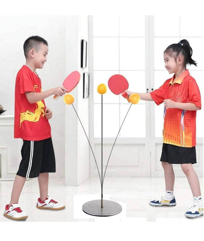 Kids playing table tennis ping with red paddles and orange balls in a bright indoor setting