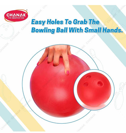 Red bowling ball with easy grip holes for kids in a bowling pins set-up