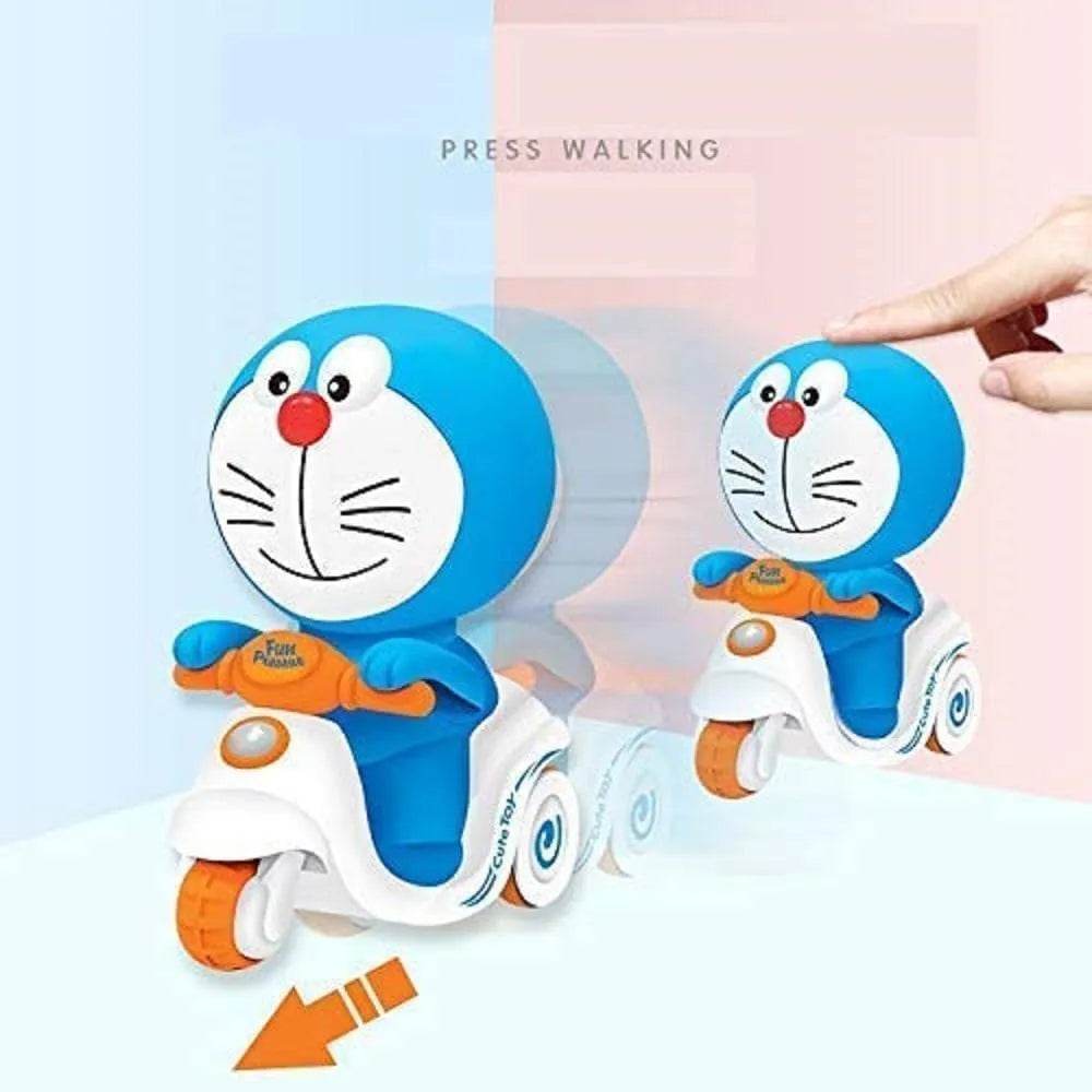 Doraemon push and go toy riding a white scooter with orange wheels and a hand pressing it to activate