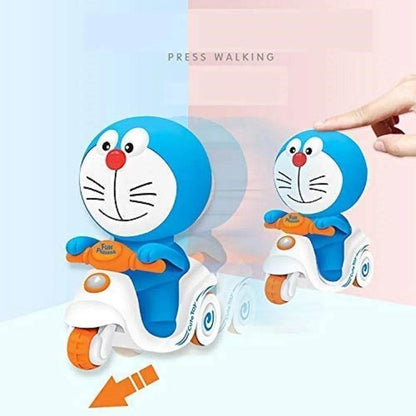 Doraemon push and go toy riding a white scooter with orange wheels and a hand pressing it to activate