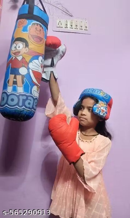 Child wearing boxing gloves and a helmet, standing next to a colorful punching bag against a light purple wall.