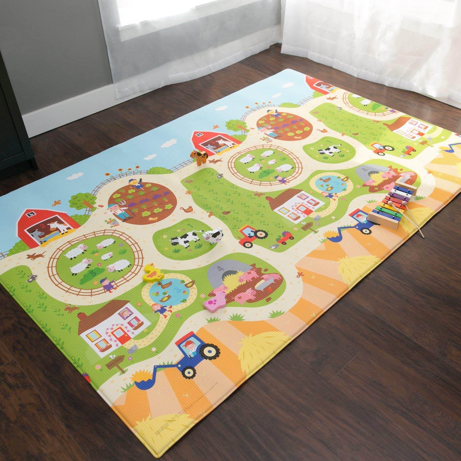 Unimates farm themed baby mat with colorful farm animals and tractors on a soft play surface