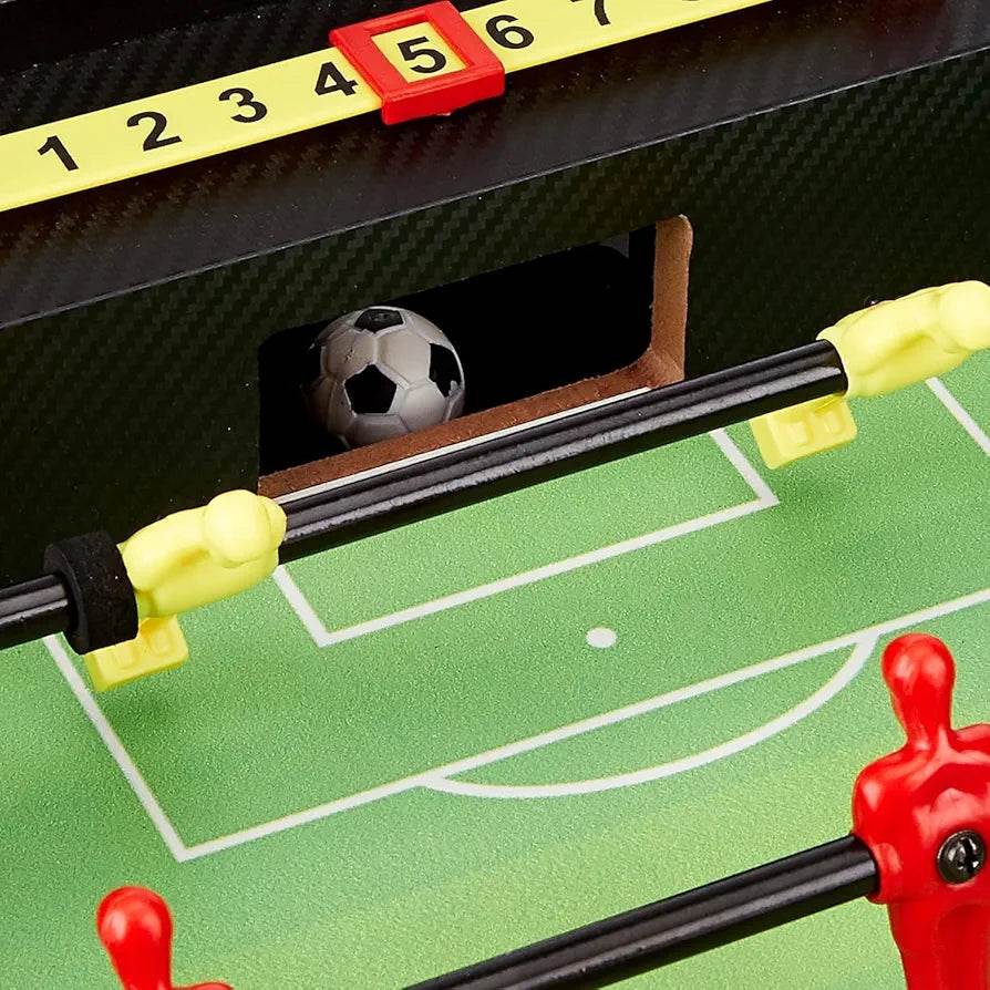Small foosball football board showing goal area with black and white ball and yellow and red player figures
