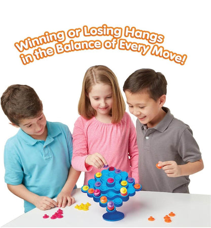 Colorful board game with children ages 5-8 balancing pieces on a tree structure