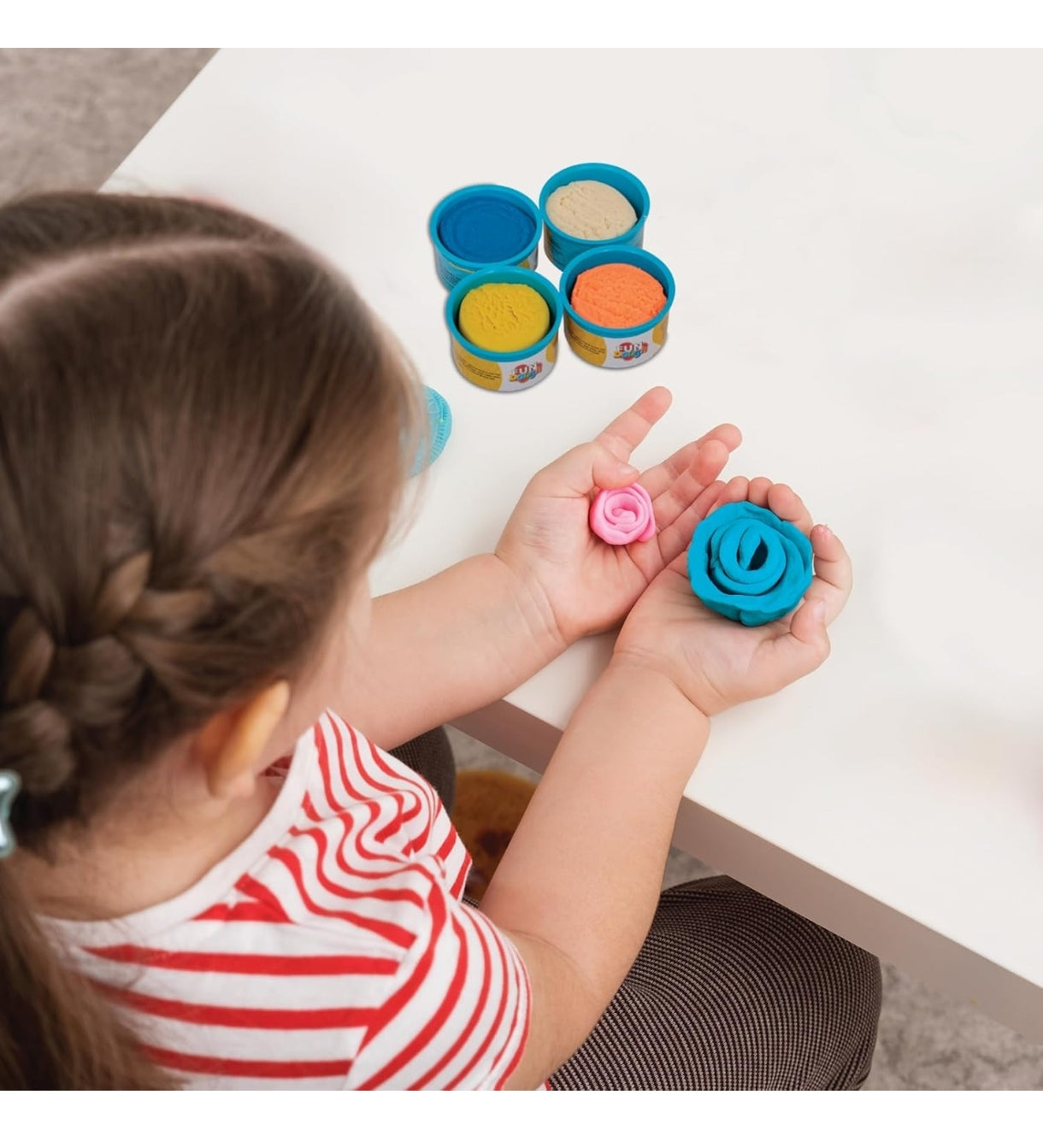 Child crafting flowers with colorful play dough in blue and pink, great for recipes play dough fun