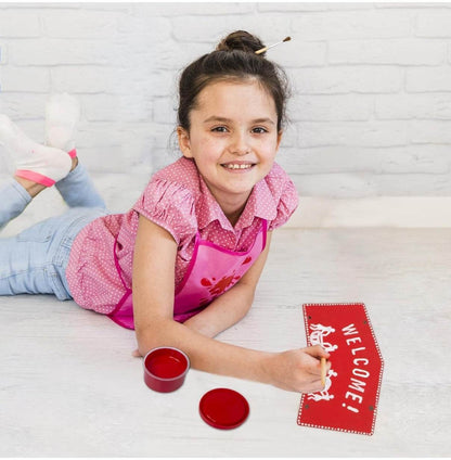 Girl painting a red welcome sign with Warli art designs using Warli art DIY kit for kids