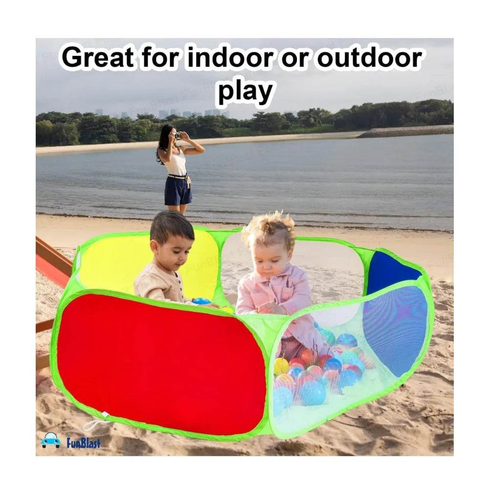 Kids ball pool with balls in bright colors set up outdoors on sandy beach with two toddlers playing inside