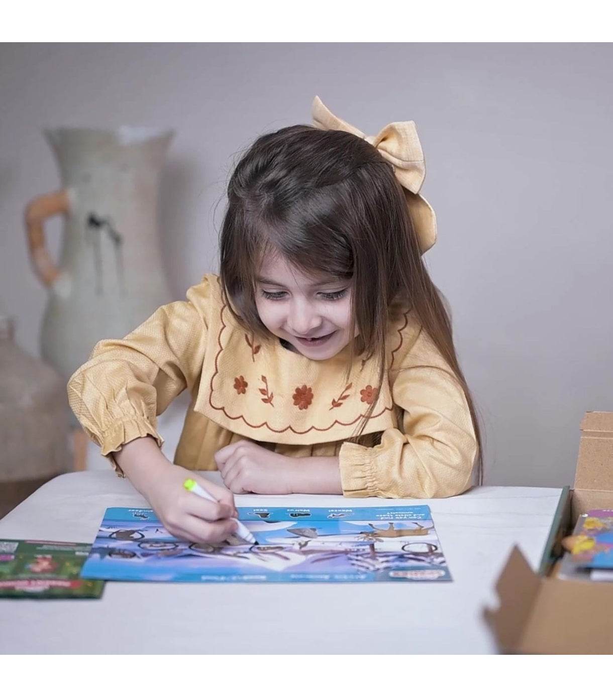 Young girl enjoying a preschool activity kit 3-6 years while drawing on a colorful activity sheet