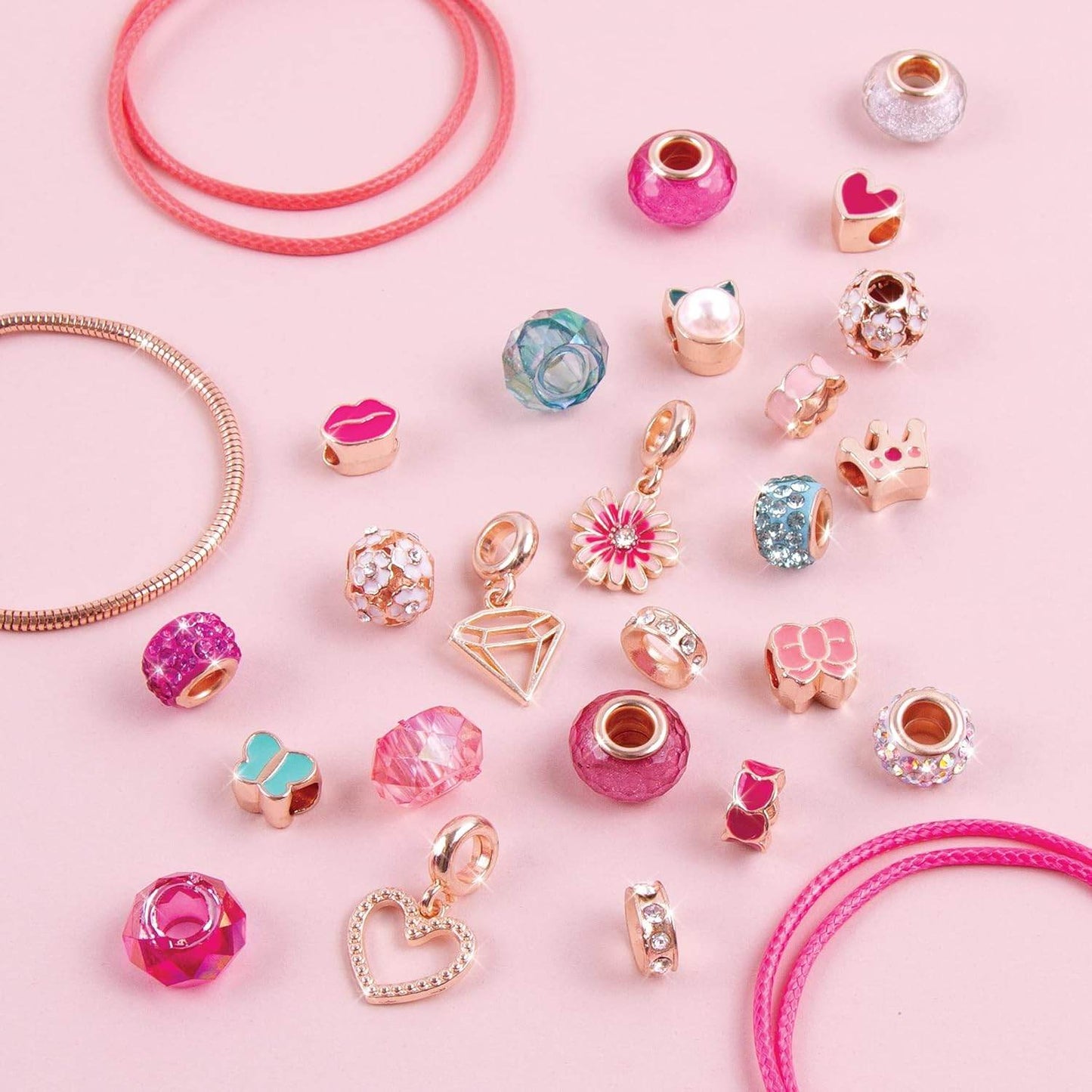 DIY charm bracelet kit for kids with colorful beads and gold-tone charms on pink background