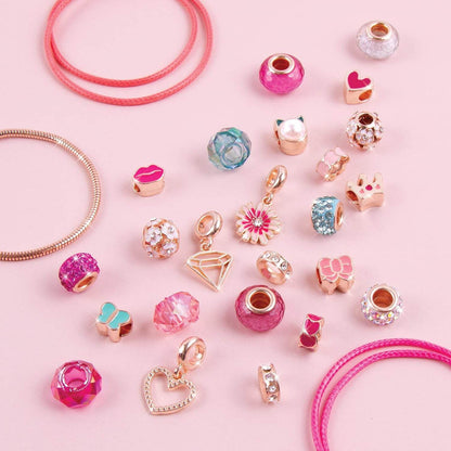 DIY charm bracelet kit for kids with colorful beads and gold-tone charms on pink background