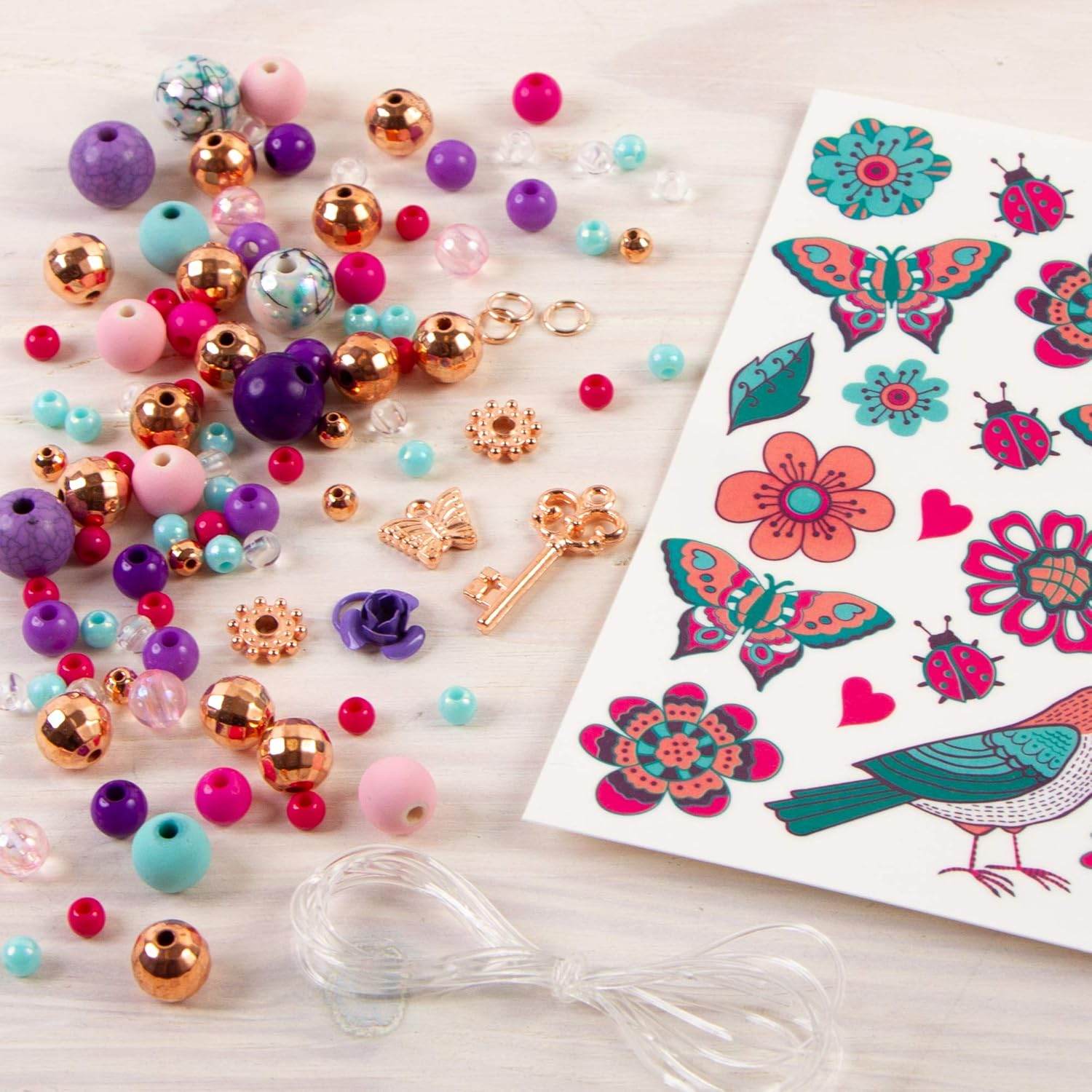 DIY jewelry kit for girls with colorful beads, decorative charms, stickers, and clear string for crafting