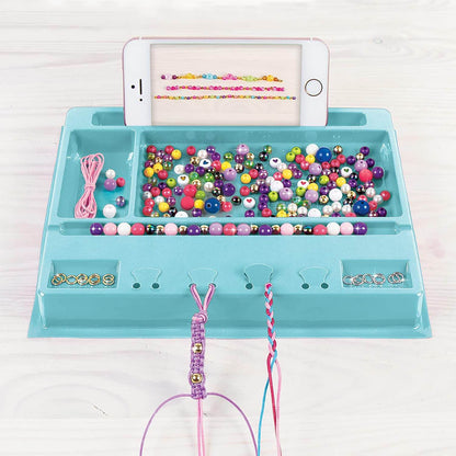 Make your own jewelry set with colorful beads and strings organized on a blue tray with phone holder