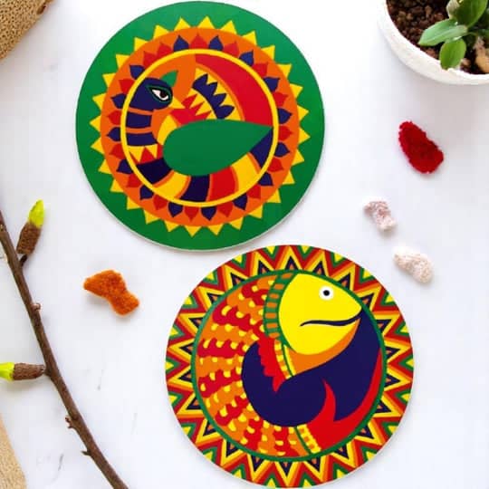 Colorful coasters featuring vibrant mithila painting madhubani designs depicting fish and birds