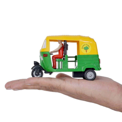 Pull back auto rickshaw toy in green and yellow with a driver figure held on a hand by T-Rex the toyland Sitamarhi