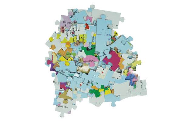 Scattered pieces of educational India puzzle game 99 pieces showing colorful map sections